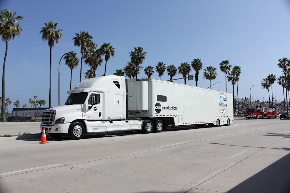 A large white truck parked on a sunny day in Long Beach, CA, with palm trees and blue sky.